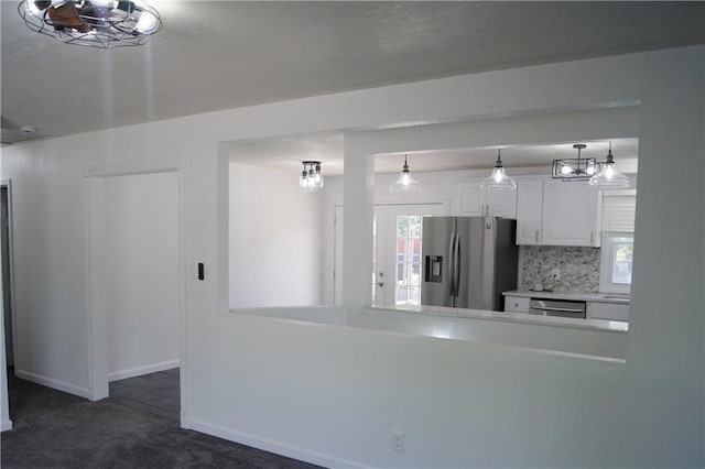 1919 Seneca St, Leavenworth, KS 66048 - kitchen with stainless steel appliances, dark carpet, white cabinets, decorative backsplash, and baseboards