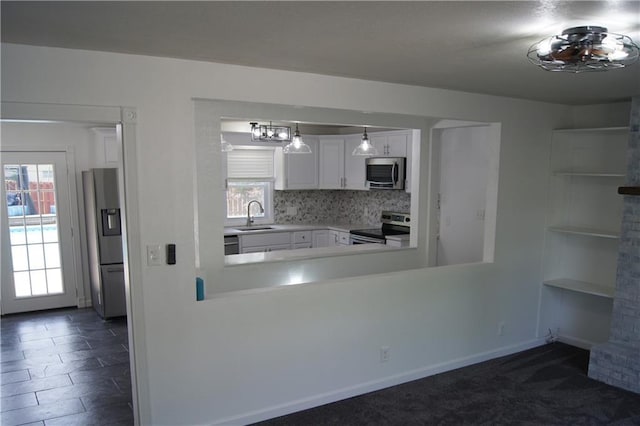 1919 Seneca St, Leavenworth, KS 66048 - kitchen featuring appliances with stainless steel finishes, a sink, white cabinetry, light countertops, and backsplash
