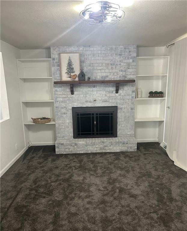 1919 Seneca St, Leavenworth, KS 66048 - unfurnished living room with dark carpet, a textured ceiling, a fireplace, baseboards, and built in shelves
