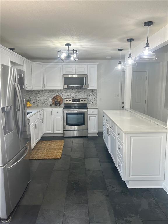 1919 Seneca St, Leavenworth, KS 66048 - kitchen with appliances with stainless steel finishes, white cabinetry, and backsplash