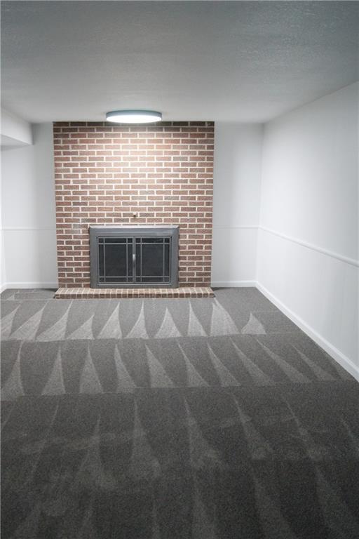 1919 Seneca St, Leavenworth, KS 66048 - unfurnished living room with a fireplace, carpet flooring, and baseboards