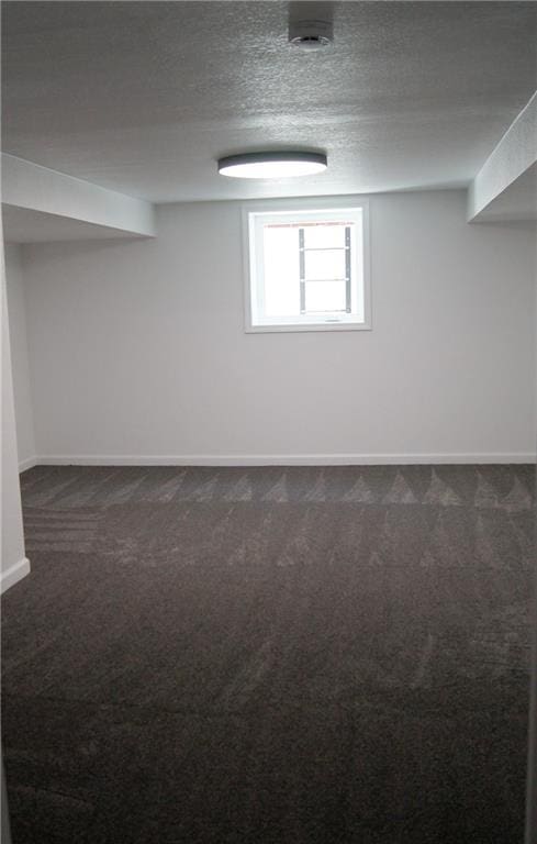 1919 Seneca St, Leavenworth, KS 66048 - below grade area with dark carpet, baseboards, and a textured ceiling