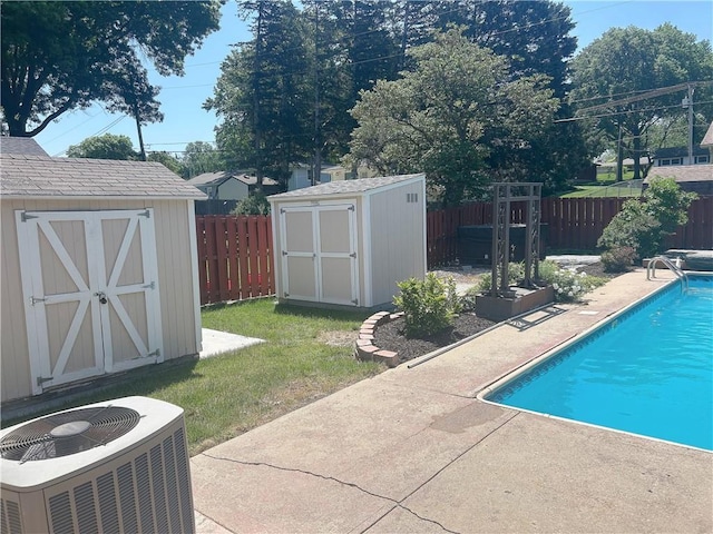 1919 Seneca St, Leavenworth, KS 66048 - view of swimming pool featuring a storage shed, central AC, a patio, a fenced backyard, and an outbuilding