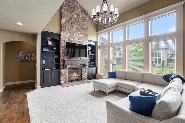 25205 W 97th Ter, Lenexa, KS 66227 - living area with a chandelier, a fireplace, high vaulted ceiling, dark wood-style floors, and arched walkways