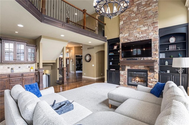 25205 W 97th Ter, Lenexa, KS 66227 - living room with wood finished floors, a fireplace, a chandelier, a high ceiling, and arched walkways