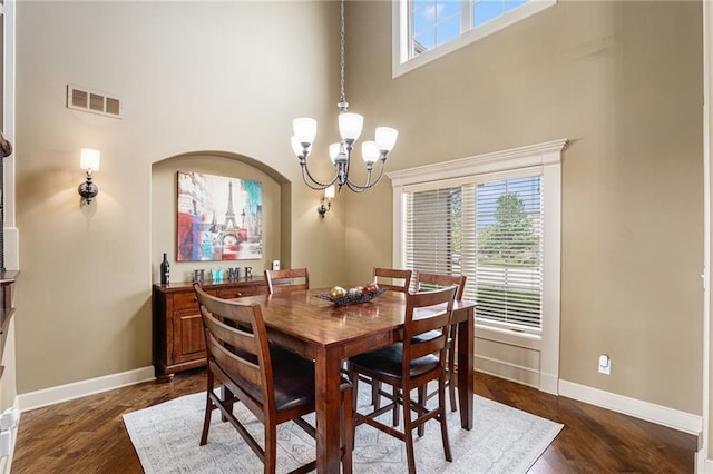 25205 W 97th Ter, Lenexa, KS 66227 - dining room featuring a chandelier, a high ceiling, healthy amount of natural light, and dark wood finished floors