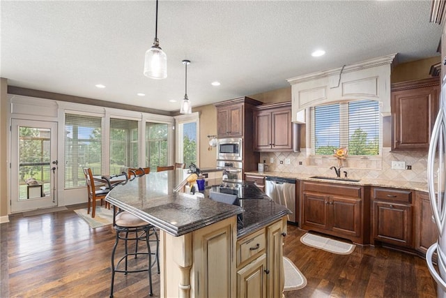 25205 W 97th Ter, Lenexa, KS 66227 - kitchen with stainless steel appliances, dark wood-type flooring, a breakfast bar, tasteful backsplash, and a textured ceiling