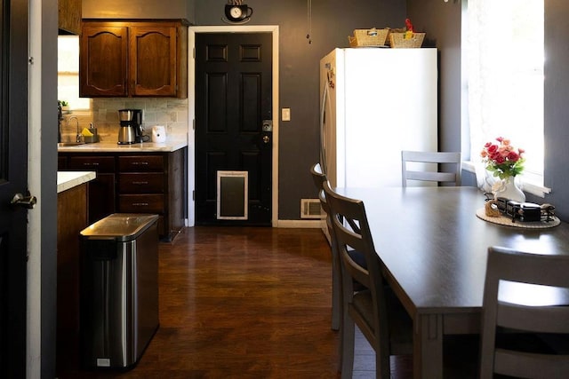 108 N Evanston Ave, Independence, MO 64053 - kitchen featuring freestanding refrigerator, light countertops, dark wood finished floors, and plenty of natural light