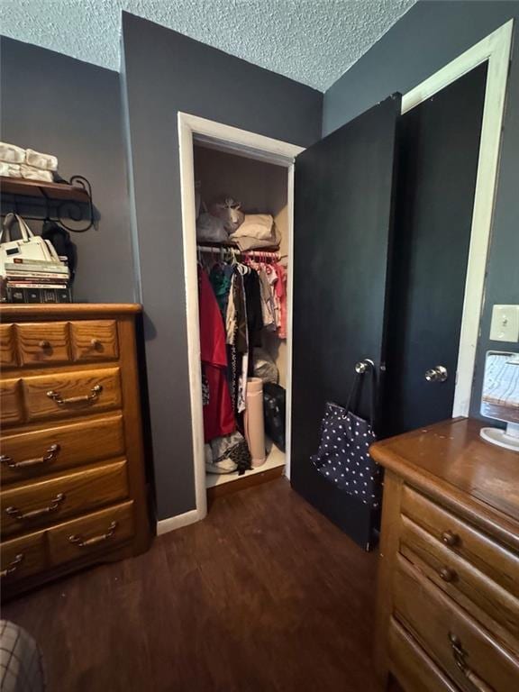 108 N Evanston Ave, Independence, MO 64053 - bedroom featuring a textured ceiling, dark wood-style flooring, a spacious closet, and a closet