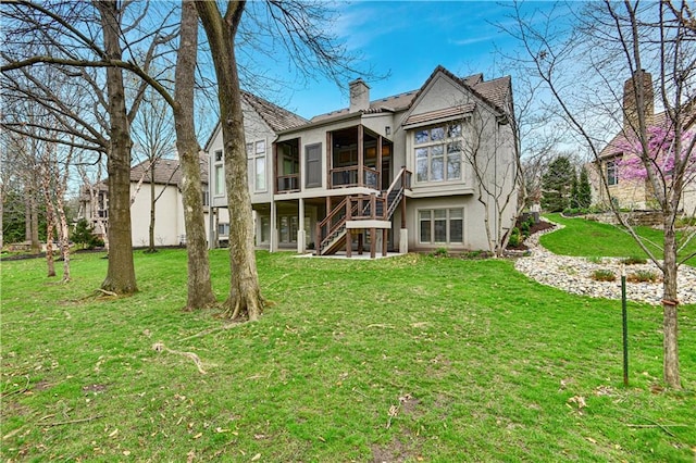 11349 Buena Vista St, Leawood, KS 66211 - back of house featuring a sunroom, stucco siding, a chimney, and a lawn