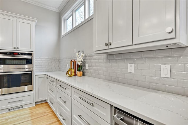 11349 Buena Vista St, Leawood, KS 66211 - kitchen with crown molding, double oven, light stone countertops, backsplash, and white cabinetry