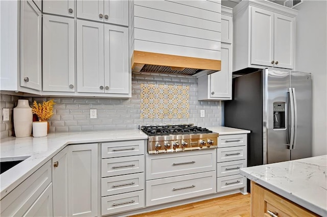 11349 Buena Vista St, Leawood, KS 66211 - kitchen with custom exhaust hood, stainless steel appliances, backsplash, light stone countertops, and white cabinetry