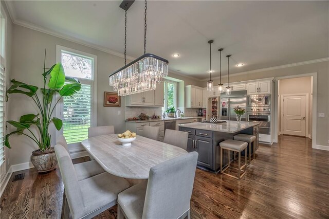 14814 Sherwood St, Leawood, KS 66224 - dining space with crown molding, dark wood-style flooring, baseboards, recessed lighting, and a chandelier