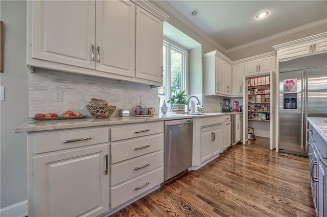 14814 Sherwood St, Leawood, KS 66224 - kitchen featuring appliances with stainless steel finishes, white cabinetry, a sink, ornamental molding, and recessed lighting