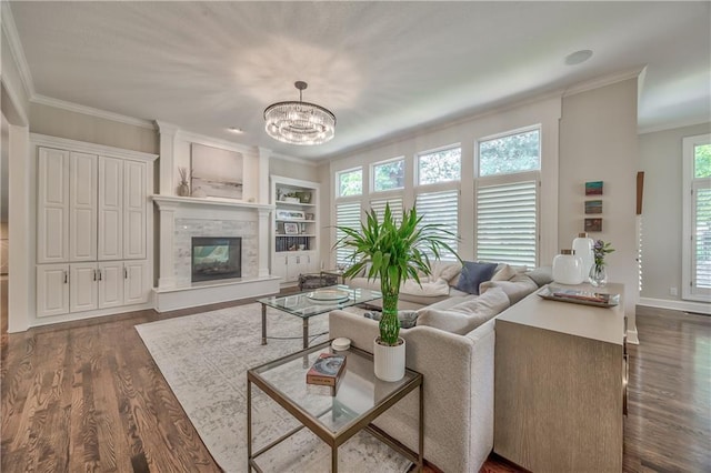14814 Sherwood St, Leawood, KS 66224 - living area with ornamental molding, dark wood-style floors, a chandelier, a glass covered fireplace, and baseboards
