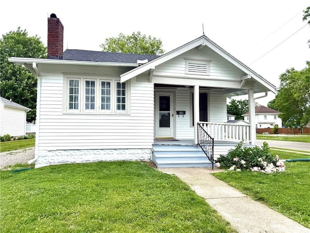 803 N Mulberry St, Maryville, MO 64468 - view of front of property featuring a porch, a front yard, a chimney, and a shingled roof