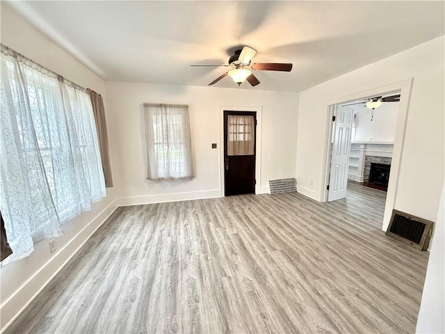 803 N Mulberry St, Maryville, MO 64468 - unfurnished living room featuring a ceiling fan, wood finished floors, a fireplace, and baseboards