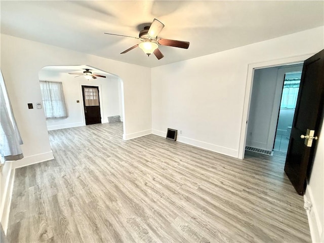 803 N Mulberry St, Maryville, MO 64468 - unfurnished living room featuring arched walkways, ceiling fan, wood finished floors, and baseboards
