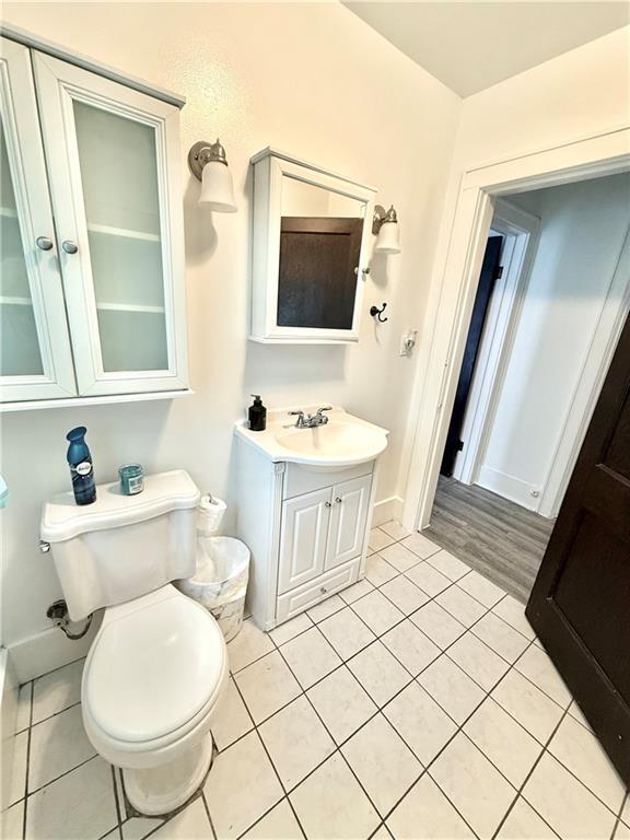 803 N Mulberry St, Maryville, MO 64468 - half bathroom with toilet, vanity, tile patterned floors, and baseboards