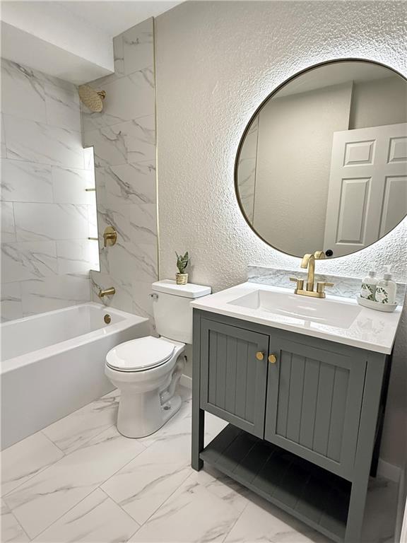 5715 Forest Ave, Kansas City, MO 64110 - bathroom with a textured wall, vanity, shower / bath combination, and marble finish floors