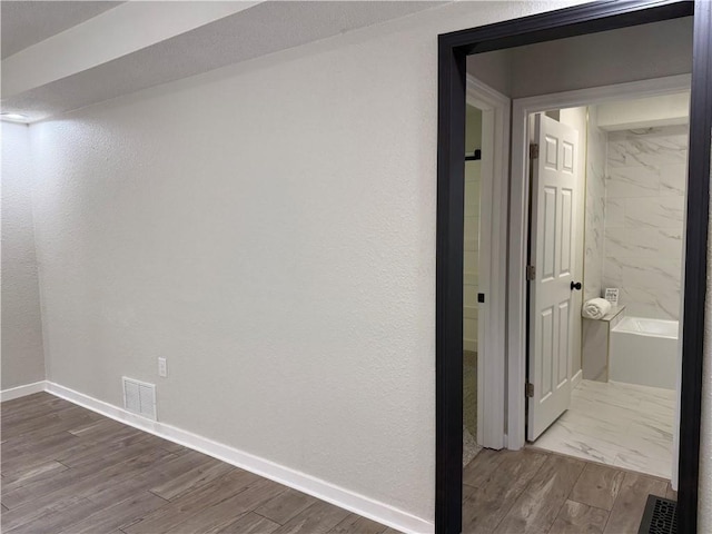 5715 Forest Ave, Kansas City, MO 64110 - corridor with dark wood-type flooring and a textured wall