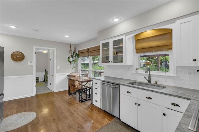 4212 NW Briarcliff Ln, Kansas City, MO 64116 - kitchen featuring stainless steel dishwasher, a sink, white cabinets, dark wood-type flooring, and light stone counters
