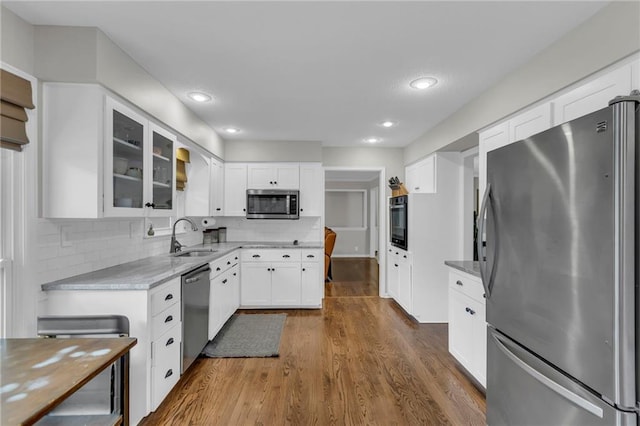 4212 NW Briarcliff Ln, Kansas City, MO 64116 - kitchen with appliances with stainless steel finishes, a sink, dark wood-style flooring, glass insert cabinets, and tasteful backsplash