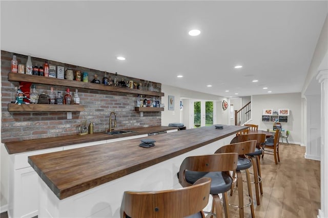 4212 NW Briarcliff Ln, Kansas City, MO 64116 - indoor wet bar with stairs, recessed lighting, light wood finished floors, and baseboards