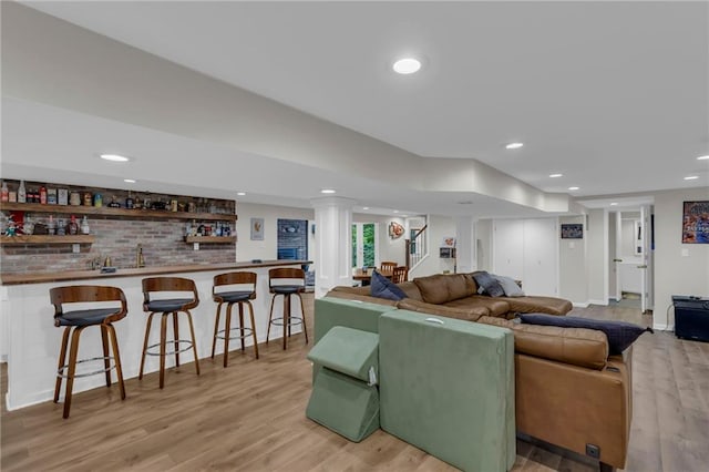 4212 NW Briarcliff Ln, Kansas City, MO 64116 - living area featuring bar with sink, light wood-style floors, recessed lighting, and baseboards