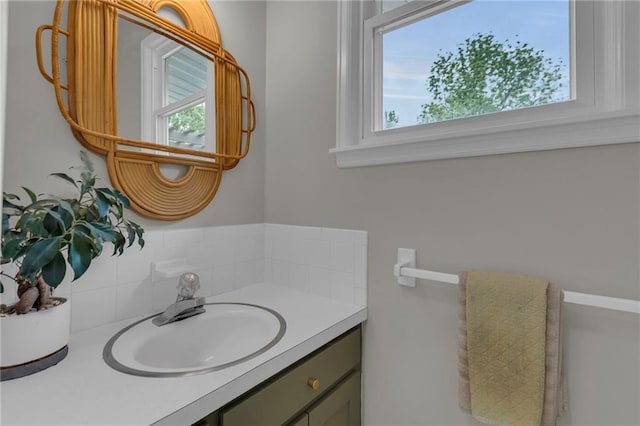 4212 NW Briarcliff Ln, Kansas City, MO 64116 - bathroom featuring decorative backsplash, vanity, and healthy amount of natural light