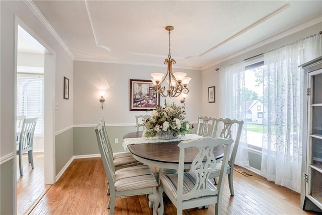 1209 NW Roanoke Dr, Blue Springs, MO 64015 - dining space featuring healthy amount of natural light, light wood-type flooring, a raised ceiling, and crown molding