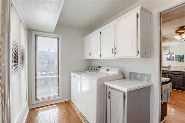1209 NW Roanoke Dr, Blue Springs, MO 64015 - washroom featuring cabinet space, washer and dryer, light wood-style flooring, and a textured ceiling