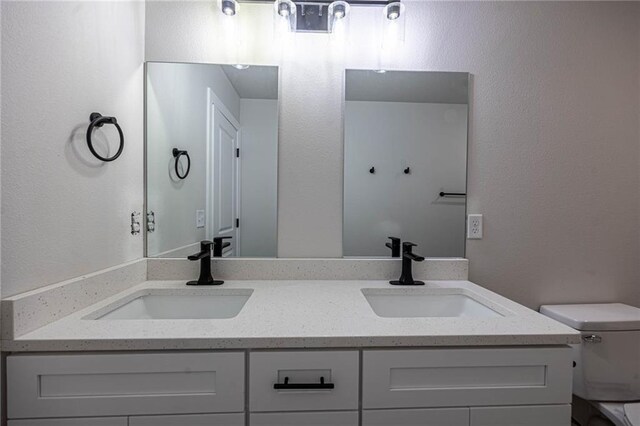 full bathroom with toilet and double vanity