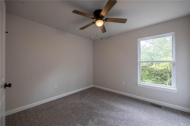 carpeted spare room with healthy amount of natural light, baseboards, and ceiling fan