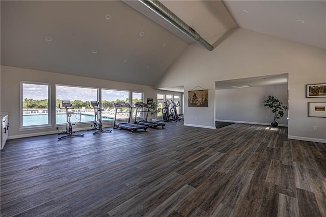 exercise room with high vaulted ceiling, baseboards, and dark wood-style floors