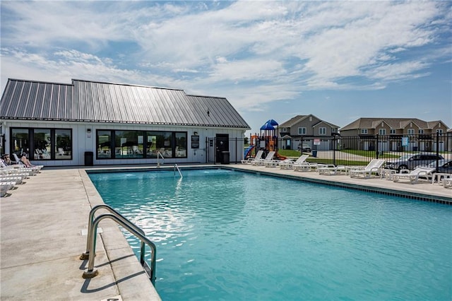 community pool with fence, a patio area, and a residential view