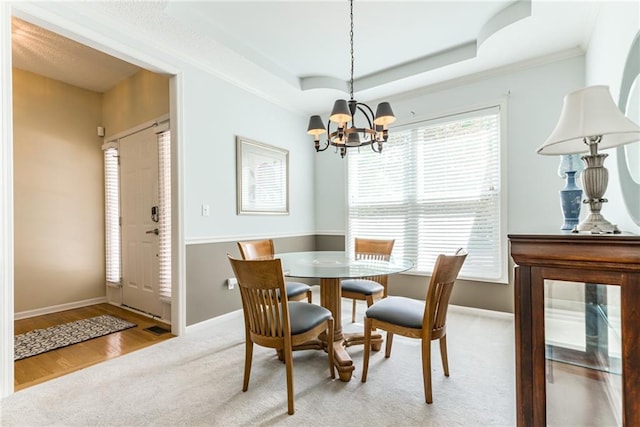 13238 Reeder St, Overland Park, KS 66213 - dining area featuring a chandelier, light carpet, baseboards, a tray ceiling, and crown molding