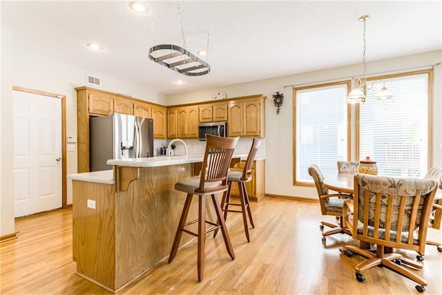 13238 Reeder St, Overland Park, KS 66213 - kitchen featuring stainless steel appliances, light countertops, light wood finished floors, healthy amount of natural light, and recessed lighting