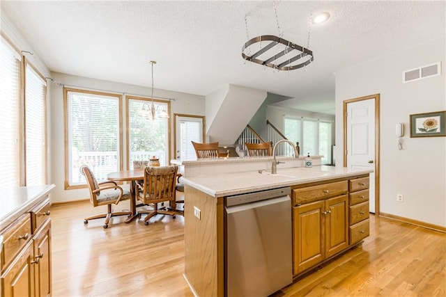 13238 Reeder St, Overland Park, KS 66213 - kitchen featuring stainless steel dishwasher, a sink, light wood-style flooring, light countertops, and healthy amount of natural light
