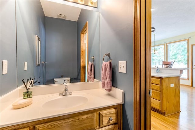 13238 Reeder St, Overland Park, KS 66213 - bathroom featuring vanity, wood finished floors, and toilet