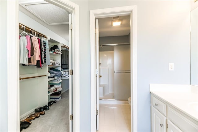 13238 Reeder St, Overland Park, KS 66213 - bathroom featuring a shower stall, vanity, a walk in closet, toilet, and a textured ceiling