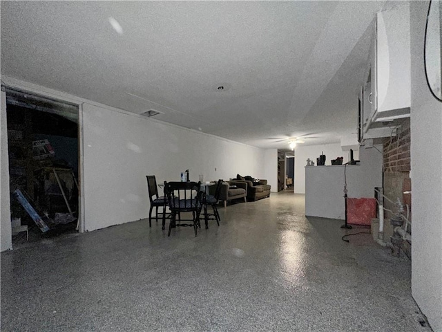misc room featuring speckle patterned floor, ceiling fan, a fireplace, and a textured ceiling