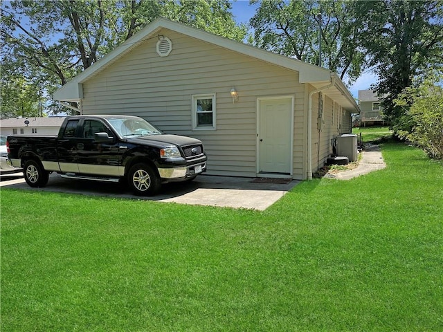 view of side of property with a lawn and central AC unit