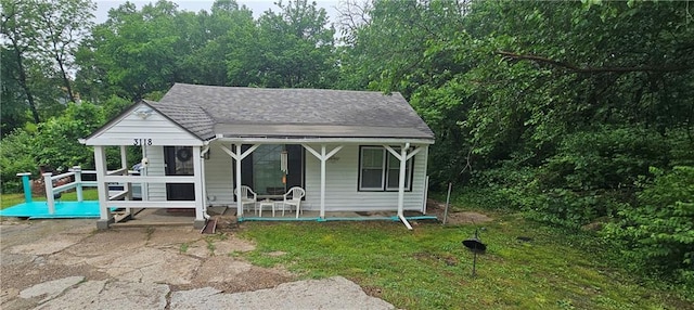 3118 Wallace Ave, Kansas City, MO 64129 - bungalow-style home featuring covered porch and a shingled roof