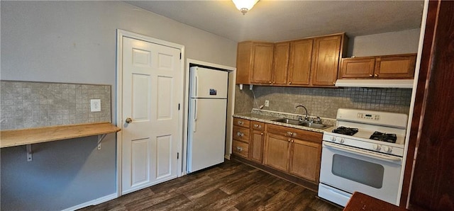 3118 Wallace Ave, Kansas City, MO 64129 - kitchen featuring white appliances, under cabinet range hood, brown cabinets, and dark wood-type flooring