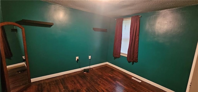3118 Wallace Ave, Kansas City, MO 64129 - spare room featuring a textured ceiling and wood finished floors