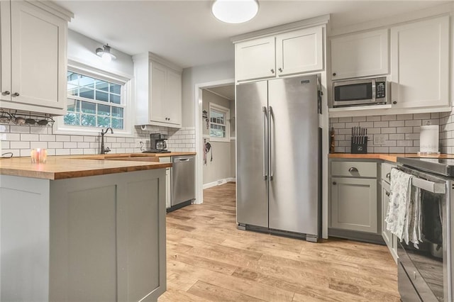 20440 147th St, Basehor, KS 66007 - kitchen with wood counters, appliances with stainless steel finishes, tasteful backsplash, and light wood finished floors