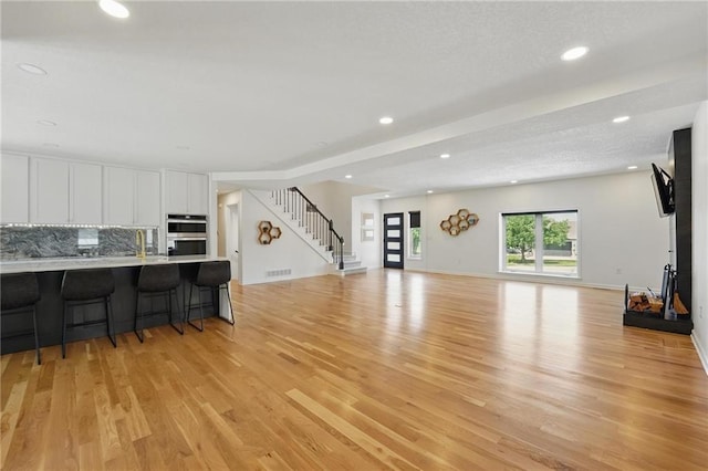 5263 SW Raintree Pkwy, Lees Summit, MO 64082 - living room with light wood-type flooring, stairs, and recessed lighting