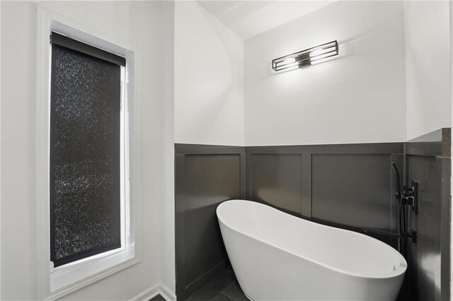 5263 SW Raintree Pkwy, Lees Summit, MO 64082 - full bath with a soaking tub, a decorative wall, and wainscoting