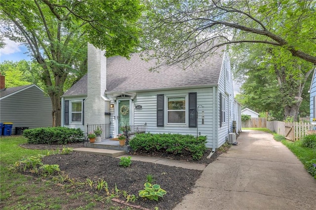 5608 Outlook St, Mission, KS 66202 - cape cod home featuring driveway, a shingled roof, and a chimney